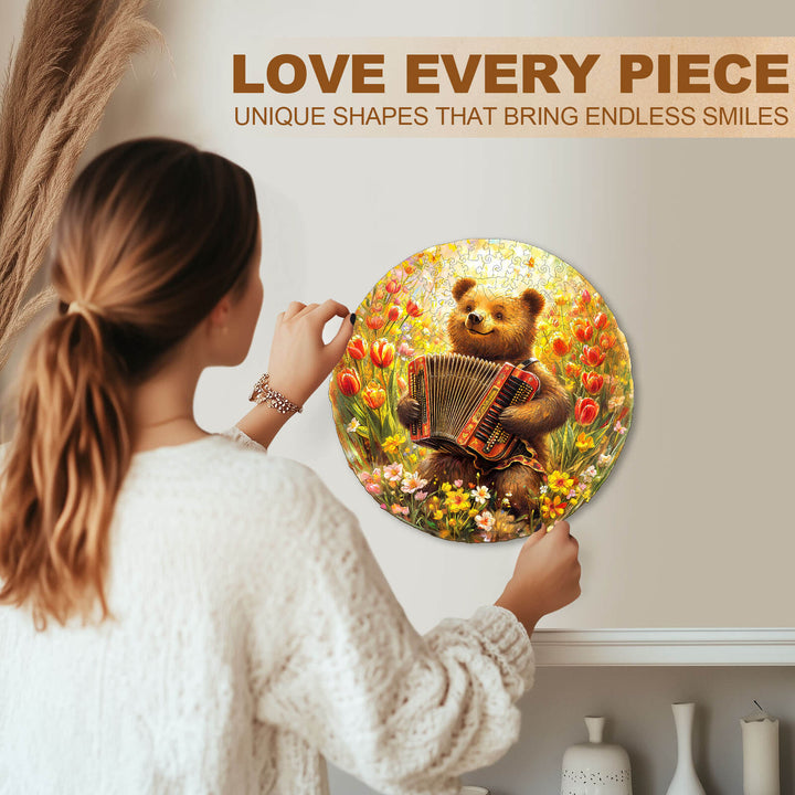 Woman assembling a round wooden jigsaw puzzle featuring a bear playing the accordion in a vibrant flower meadow.