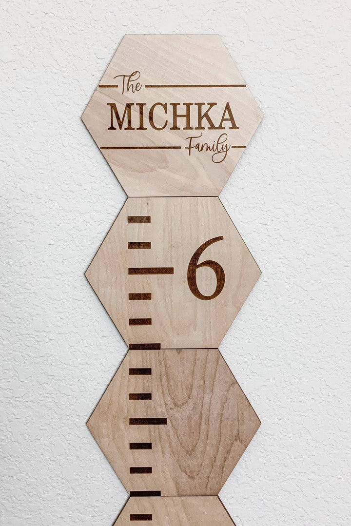 Personalized wooden hexagon growth chart for kids featuring family name and height markings.