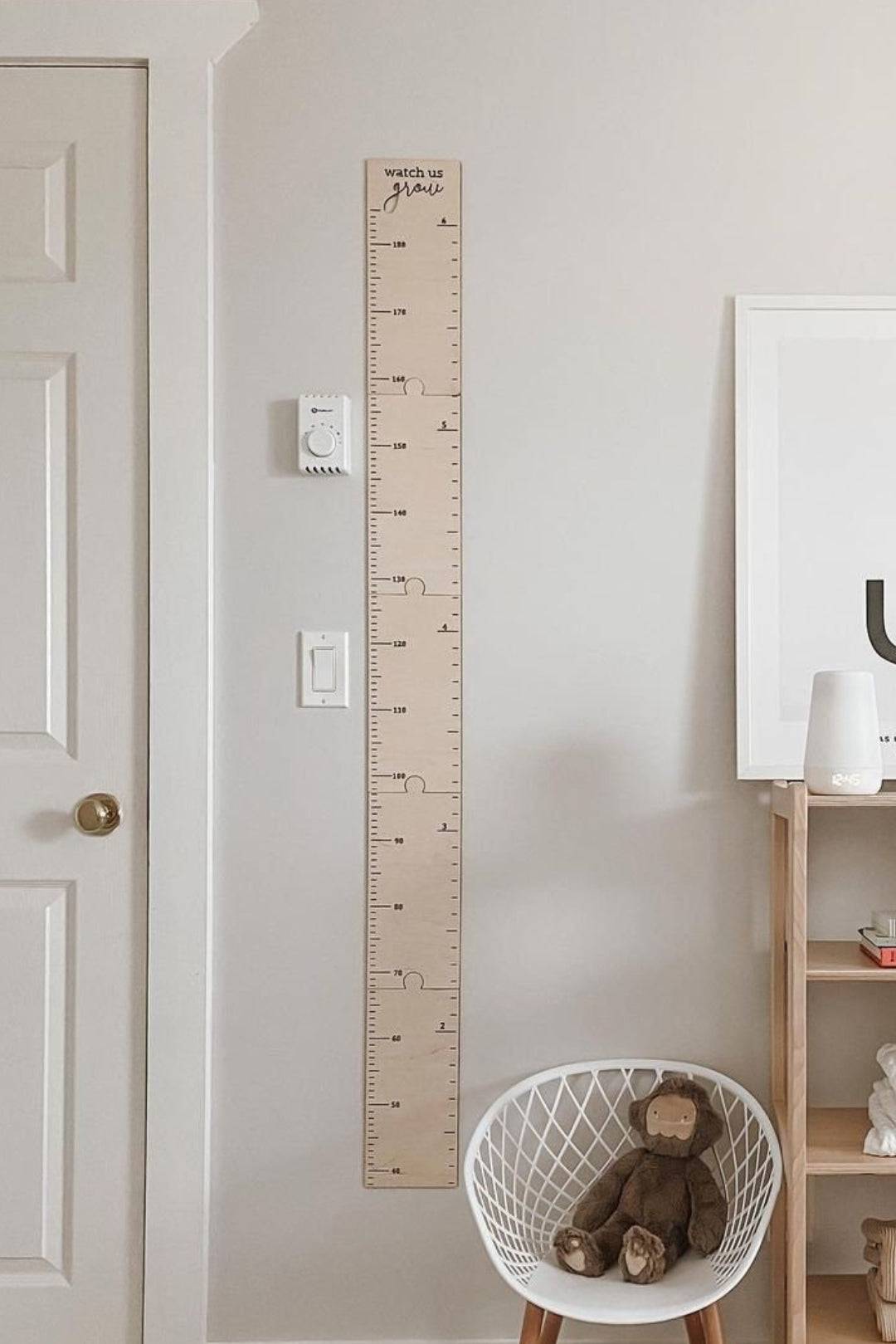 Personalized wooden growth chart height ruler on wall, perfect for kids room decor and tracking children's growth.
