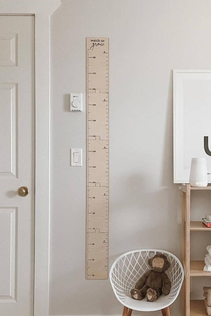 Personalized wooden growth chart height ruler on wall, perfect for kids room decor and tracking children's growth.