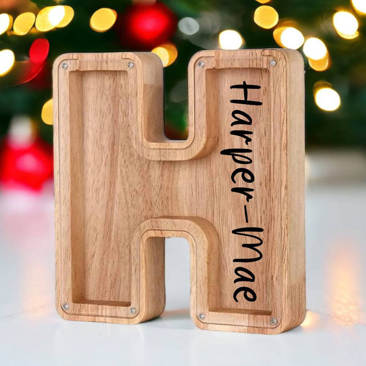 Personalized wooden letter piggy bank with the name Harper-Mae, perfect for teaching children about savings.
