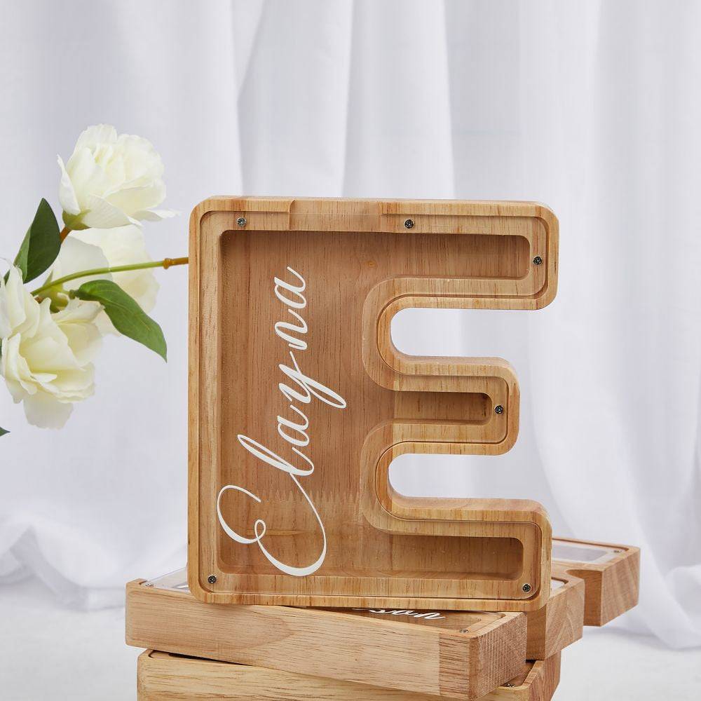 Personalized wooden letter piggy bank 'E' for kids, promoting savings and financial awareness.