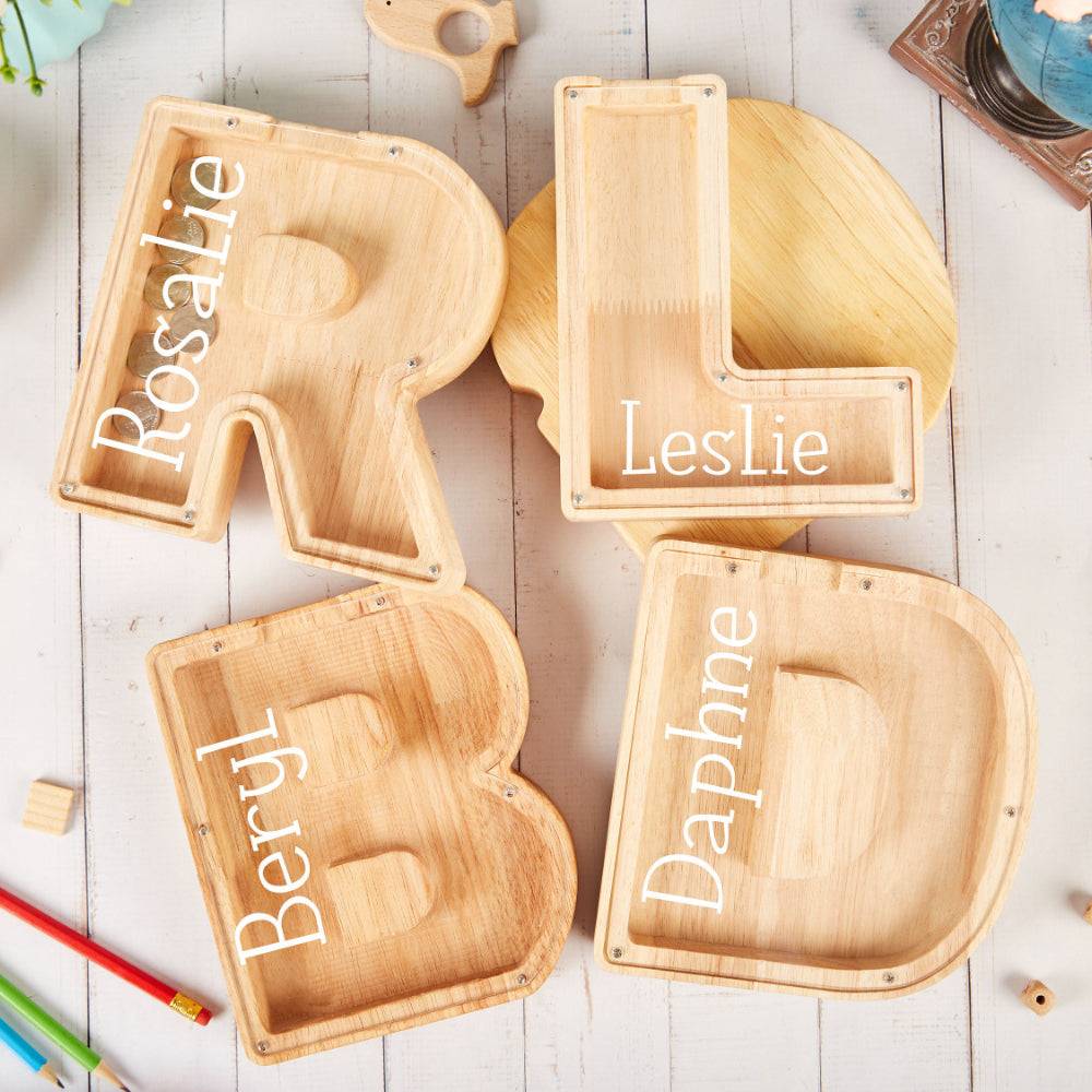 Personalized wooden letter trays with names Rosalie, Leslie, Beryl, and Daphne on a light wooden background.
