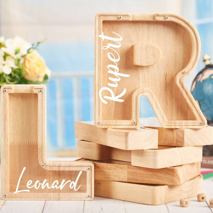 Personalized wooden letter piggy bank, letters L and R for kids, promoting savings and financial awareness.