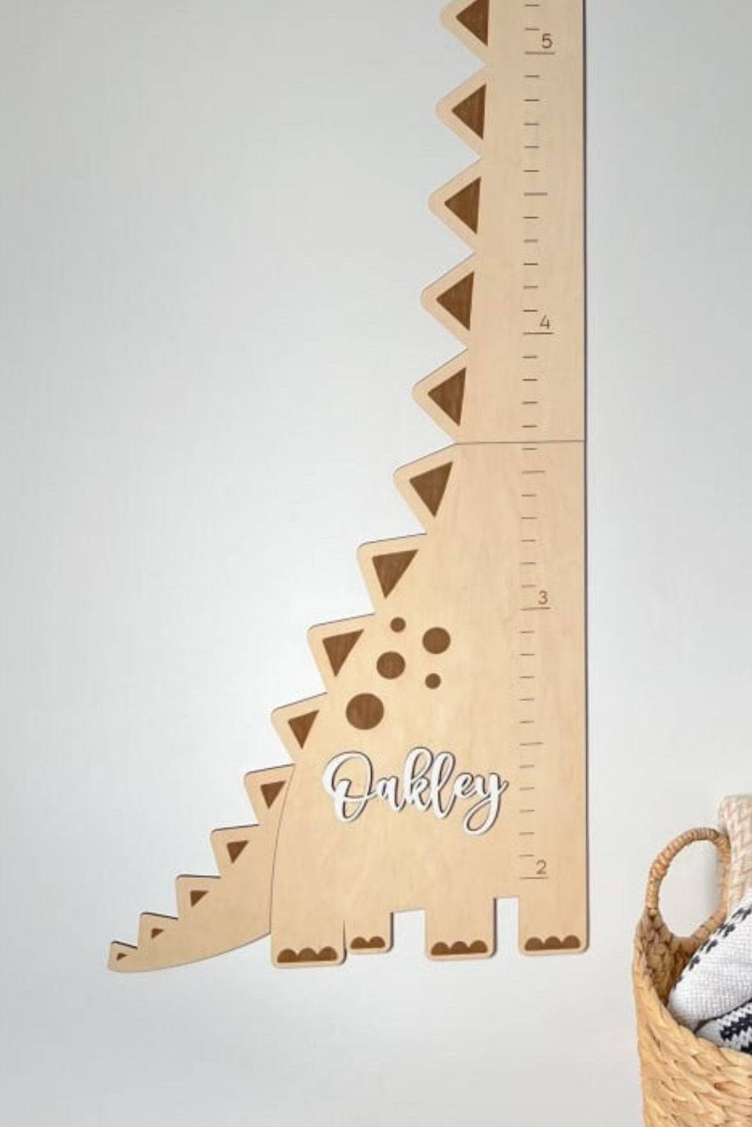 Personalized wooden dinosaur growth chart ruler with child's name, adding whimsy to any child's room decor.