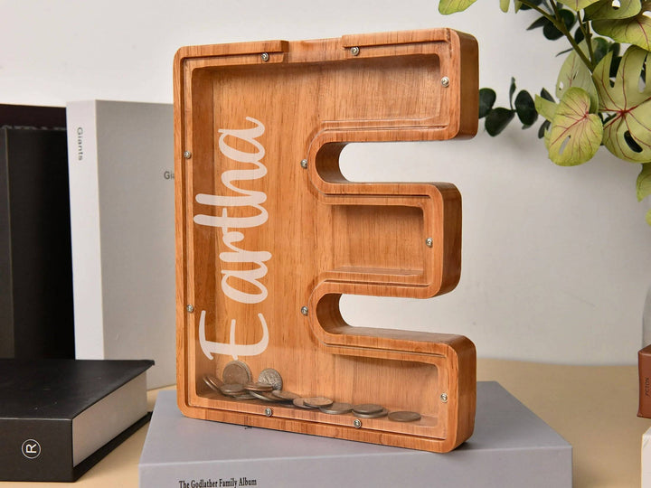 Custom wooden letter E piggy bank for kids, promoting financial awareness and savings in a stylish design.