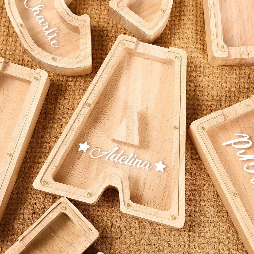 Personalized wooden letter piggy bank displaying the letter 'A' with the name 'Adelina' inscribed in a playful font.