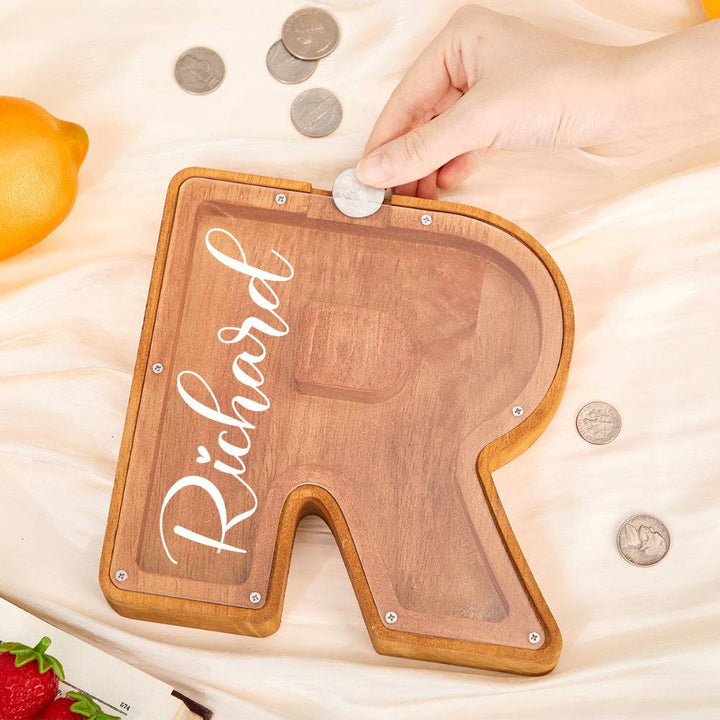 Custom wooden letter piggy bank 'R' for kids, featuring personalized name and coin slot.