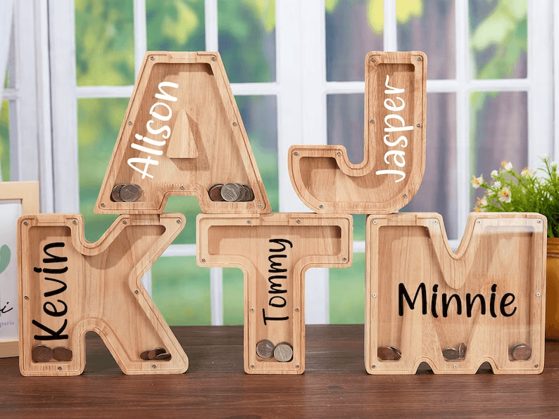 Personalized wooden letter piggy banks for kids, featuring names and coin slots to teach savings.