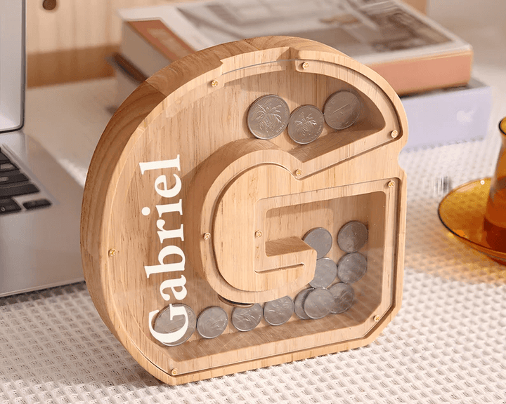 Personalized wooden letter piggy bank with coins for kids, teaching financial awareness and savings.
