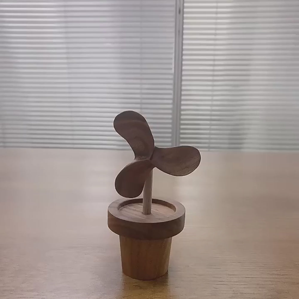 Wooden table decoration featuring a mini propeller plant in a pot, showcasing natural craftsmanship.