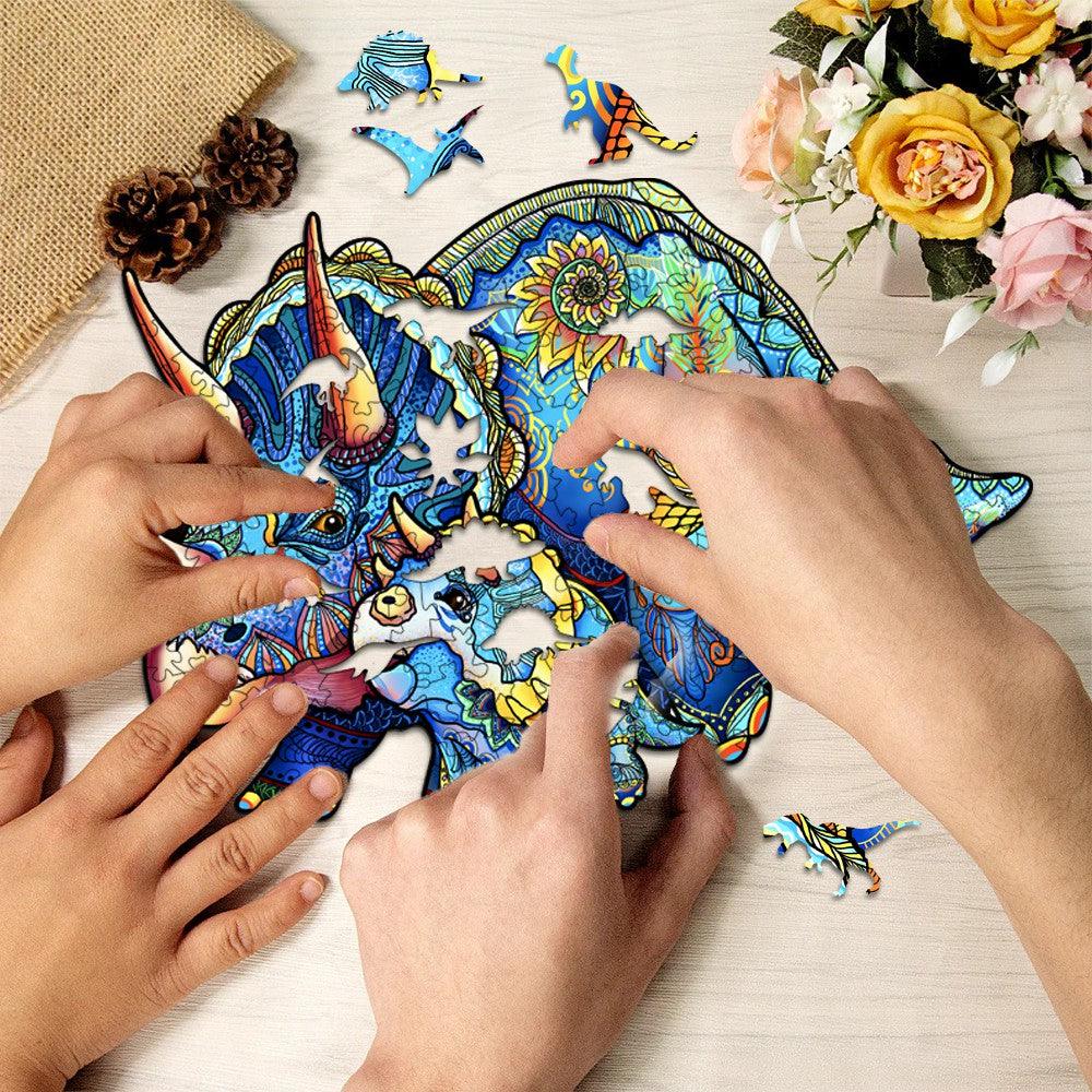 Two hands assembling a colorful Triceratops wooden jigsaw puzzle, surrounded by puzzle pieces and flowers.