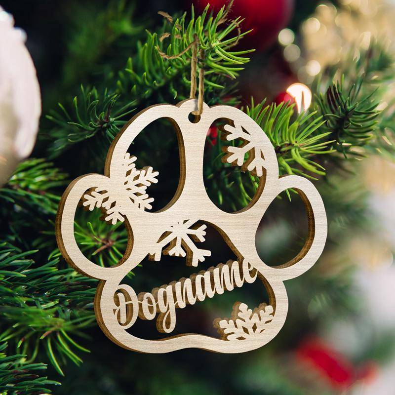 Personalized wooden dog paw ornament with snowflakes, perfect for holiday tree decorating.