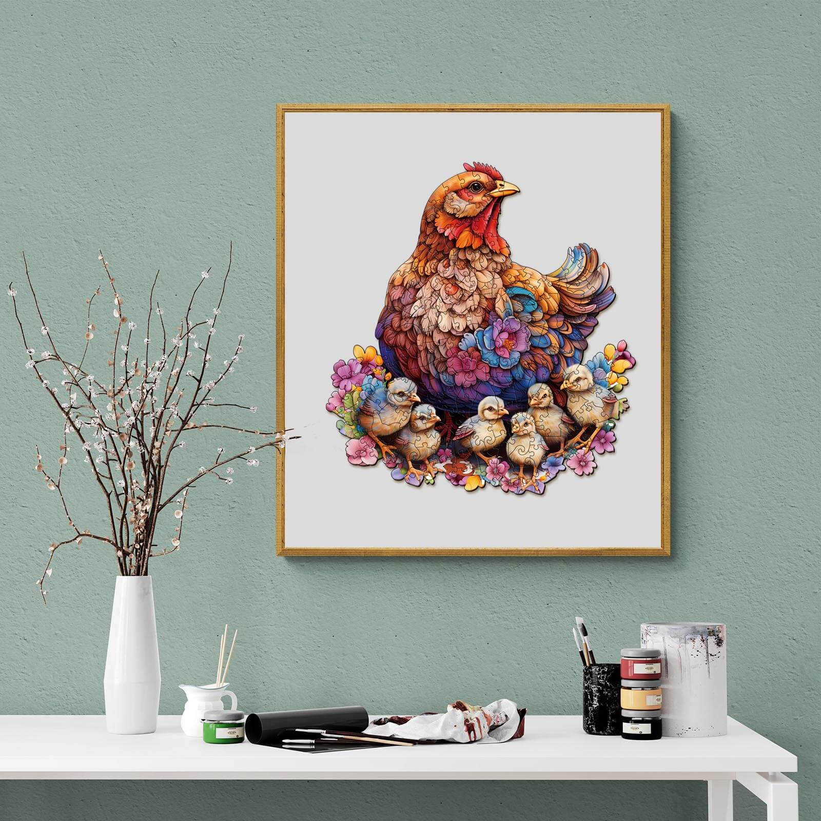 Vibrant chicken and chicks artwork in a gold frame, set against a green wall, showcasing colorful details.