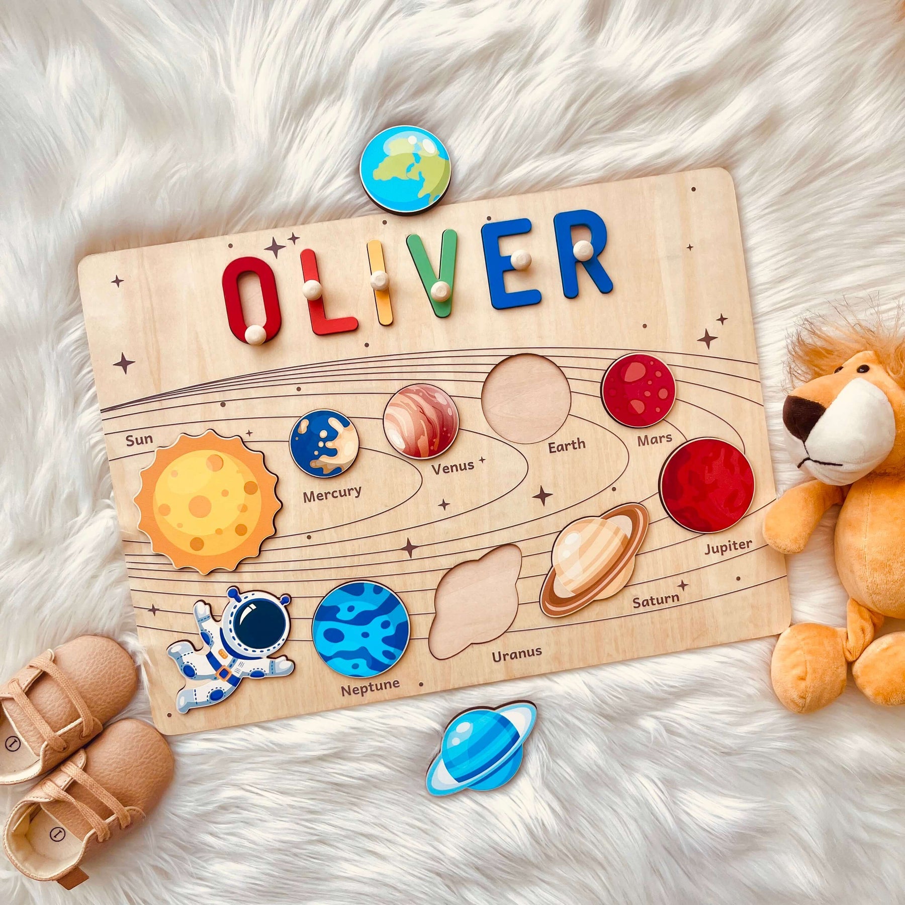 Personalized planet name puzzle with child's name Oliver, featuring solar system illustrations and colorful wooden pieces.