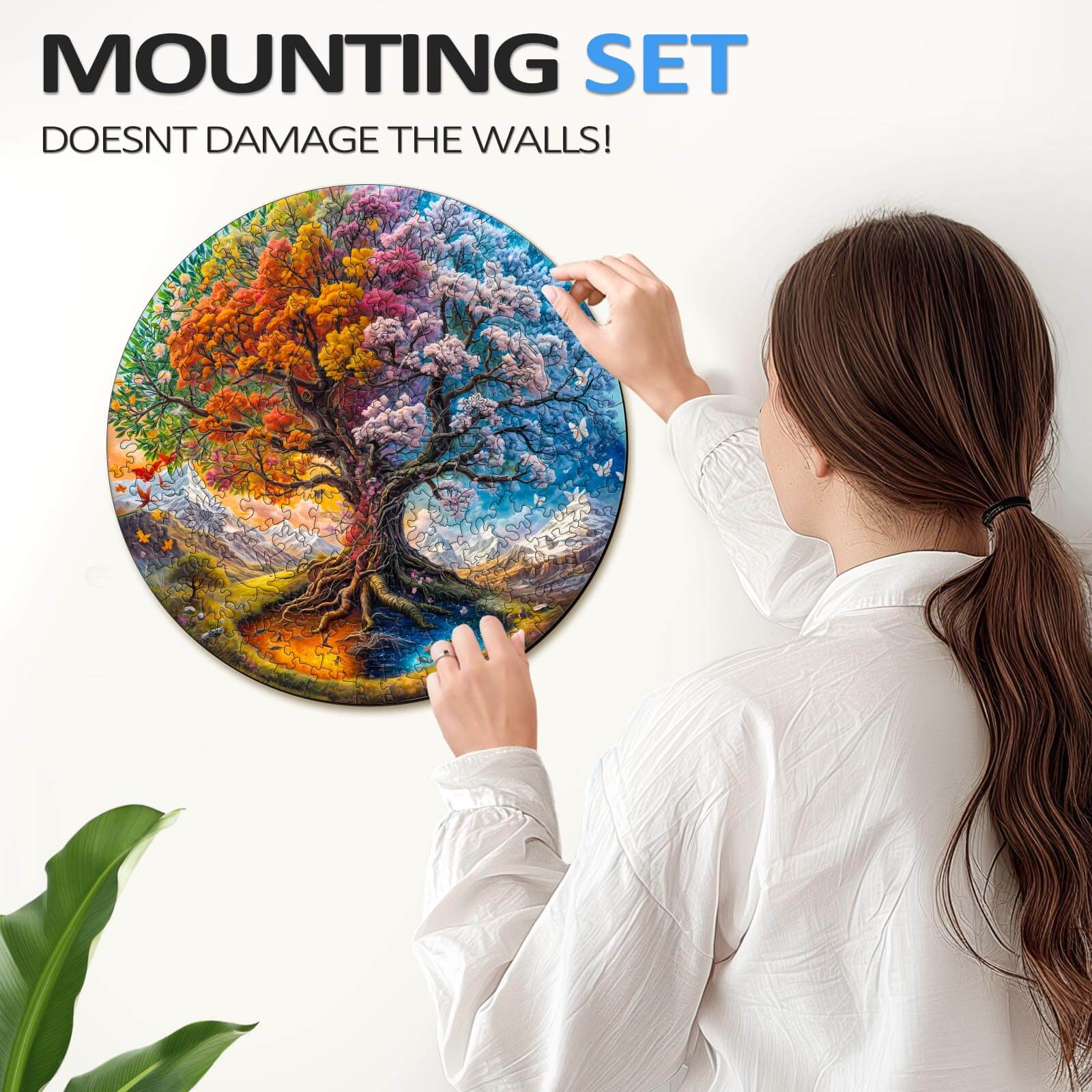 Woman mounting the Seasonal Tree of Life-1 wooden jigsaw puzzle on a wall without damaging it.