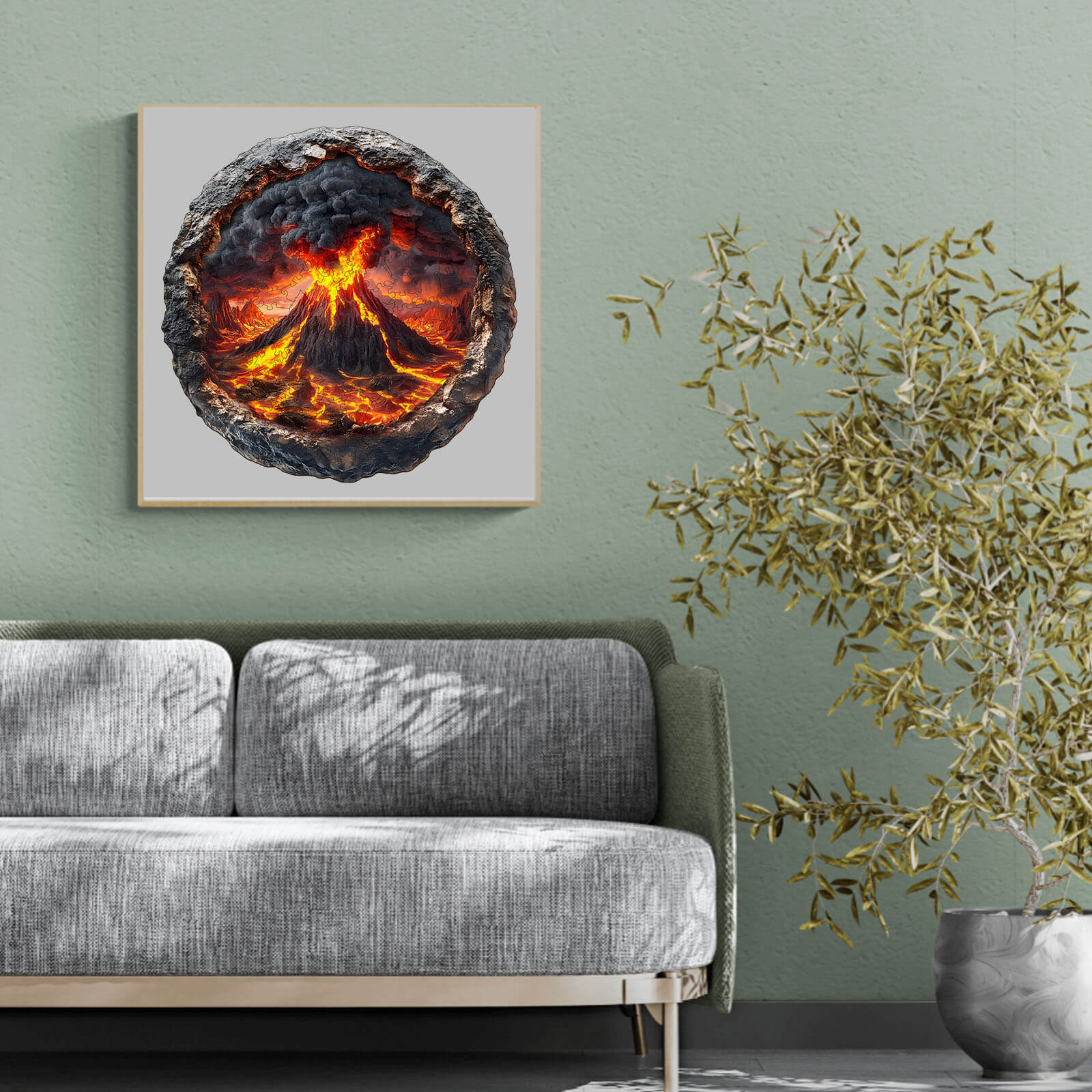 3D Volcanic Eruption puzzle art displayed above a modern gray couch in a stylish room with a plant.