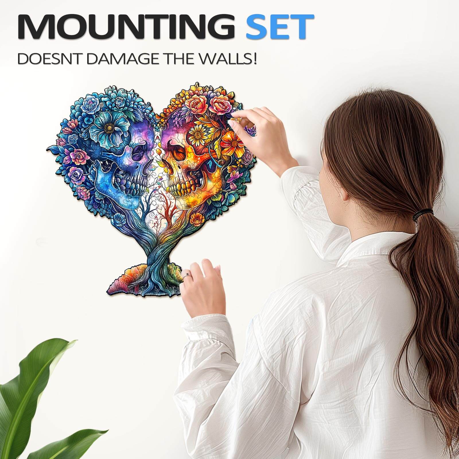 Person applying a colorful Skull and Love wall art jigsaw puzzle on a wall, showcasing a unique mounting set.