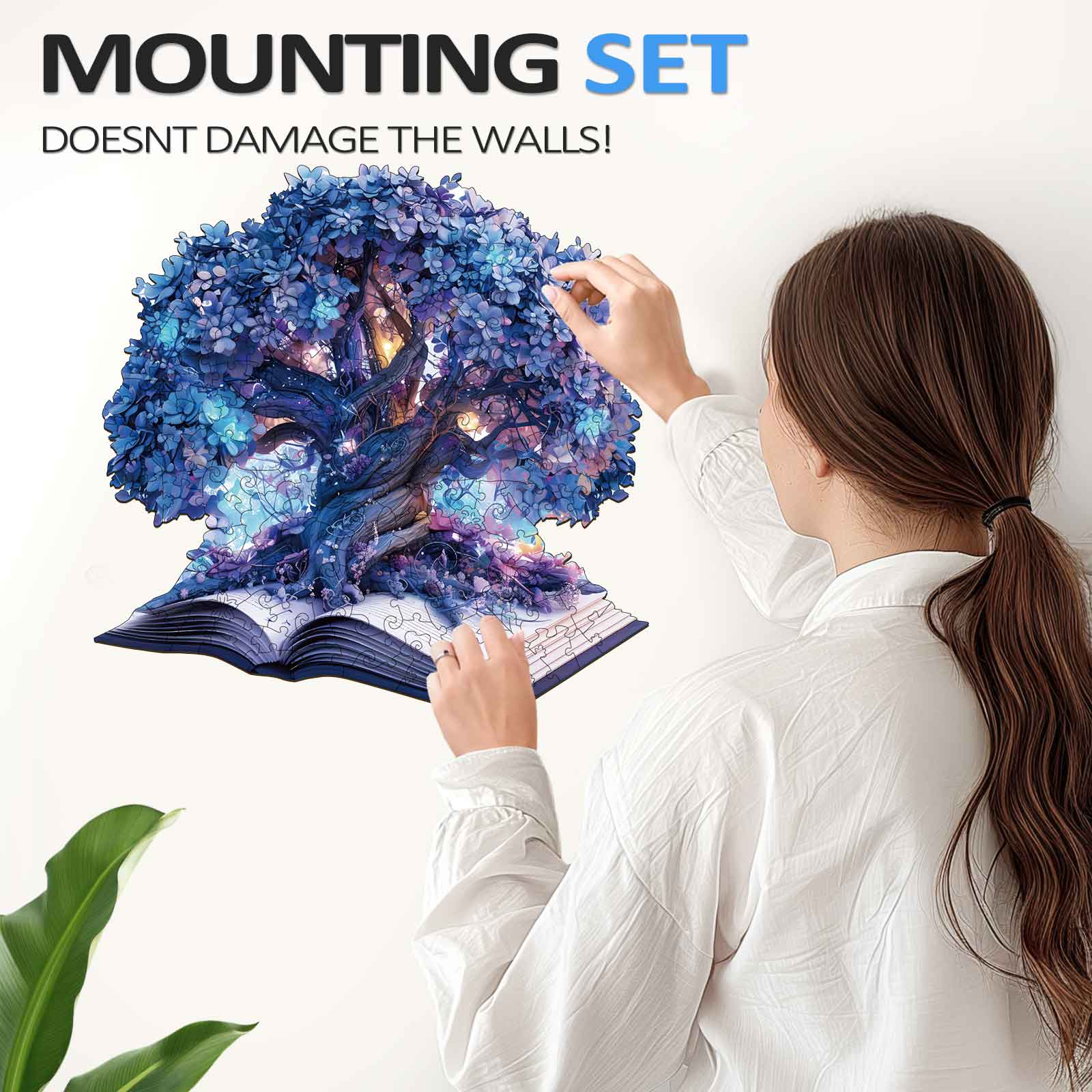 Woman mounting a 3D Magic Book wooden jigsaw puzzle on the wall without damaging surfaces.