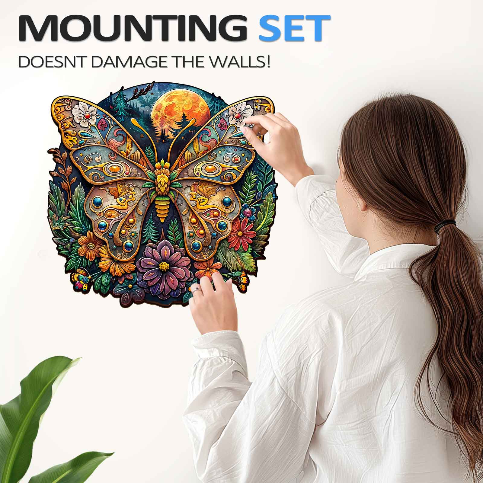 Person installing Ancient Butterfly-1 wooden jigsaw puzzle on the wall with a mounting set, designed for easy decoration.