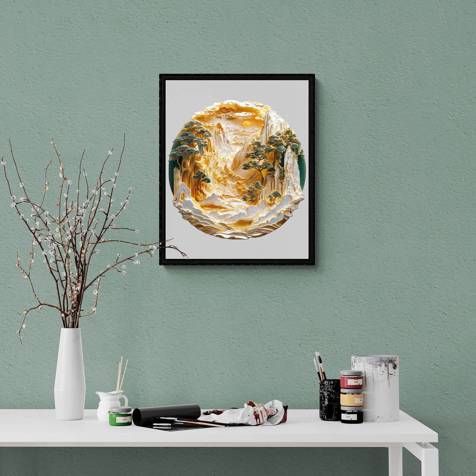 Framed 3D Golden Mountains puzzle art piece displayed on a green wall above a white table with art supplies.