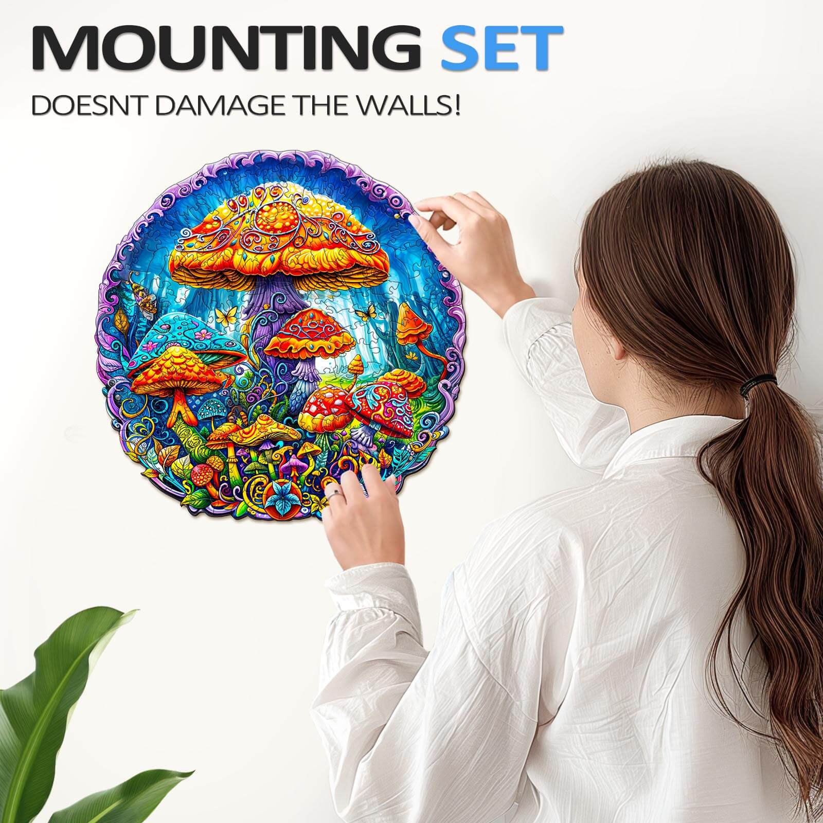 A person mounting a colorful Magical Mushrooms jigsaw puzzle on a wall with a mounting set that doesn’t damage surfaces.