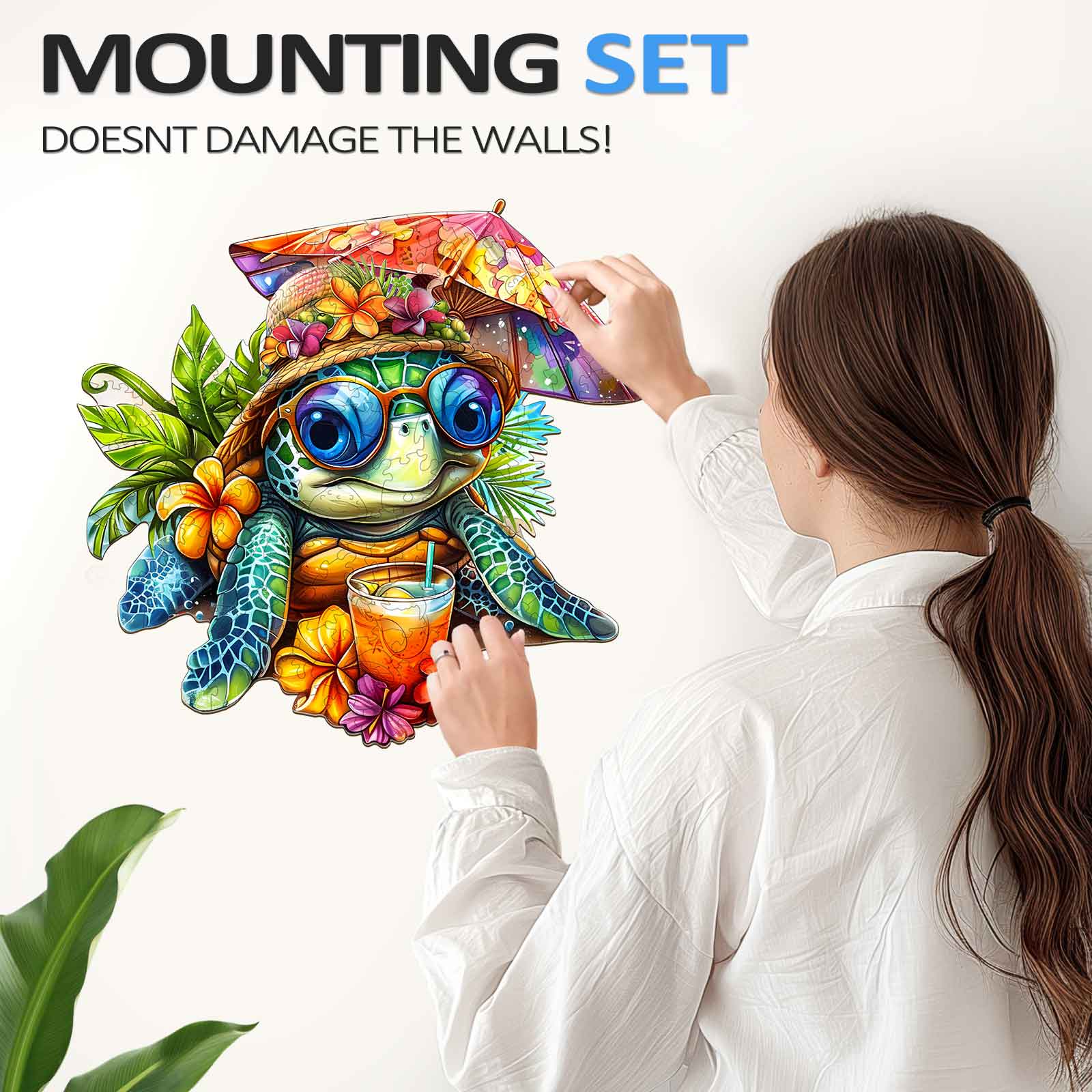 A woman mounting a vibrant beach turtle illustration on the wall, showcasing a decorative and damage-free setup.