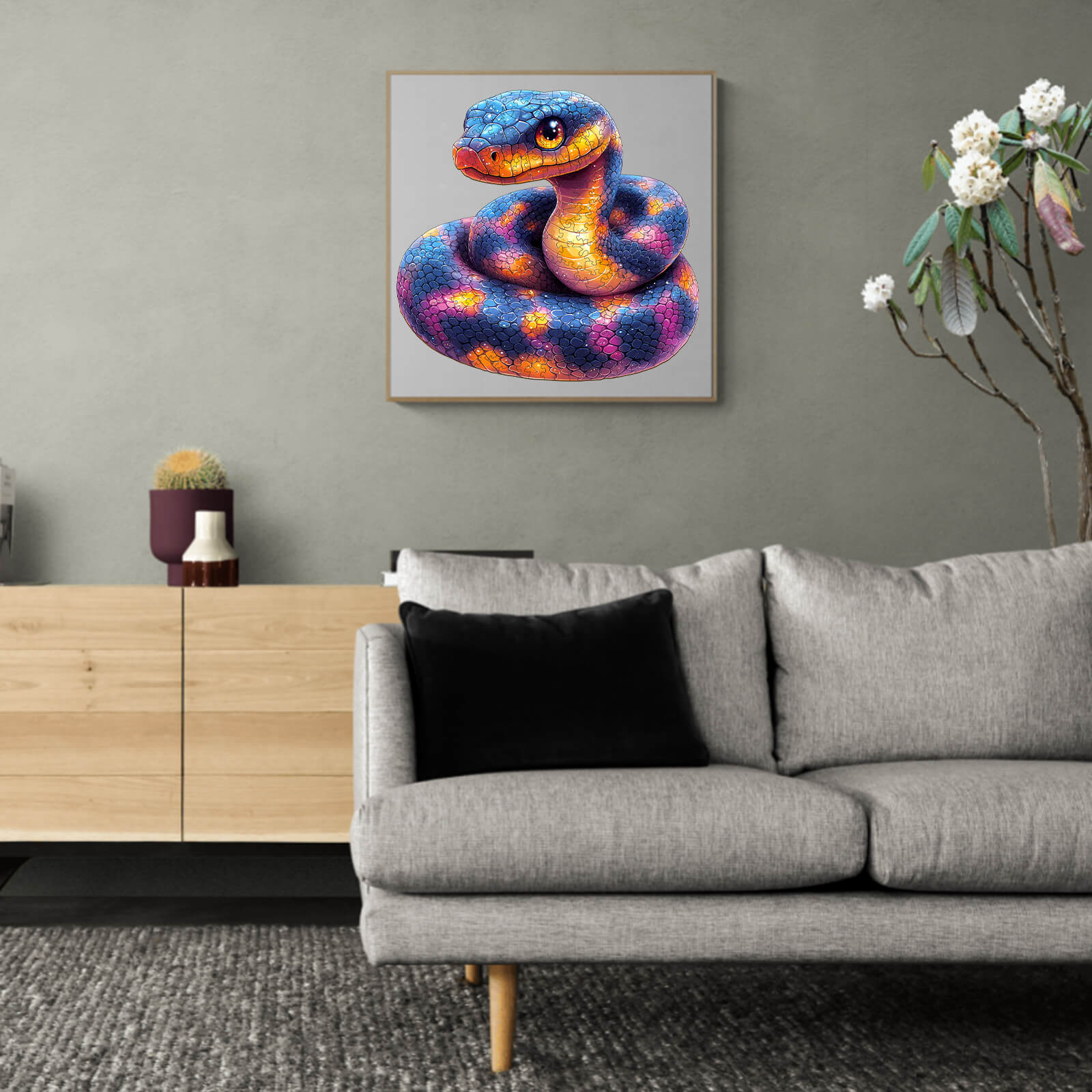 Colorful snake artwork displayed on a wall above a modern gray sofa in a stylish living room interior.