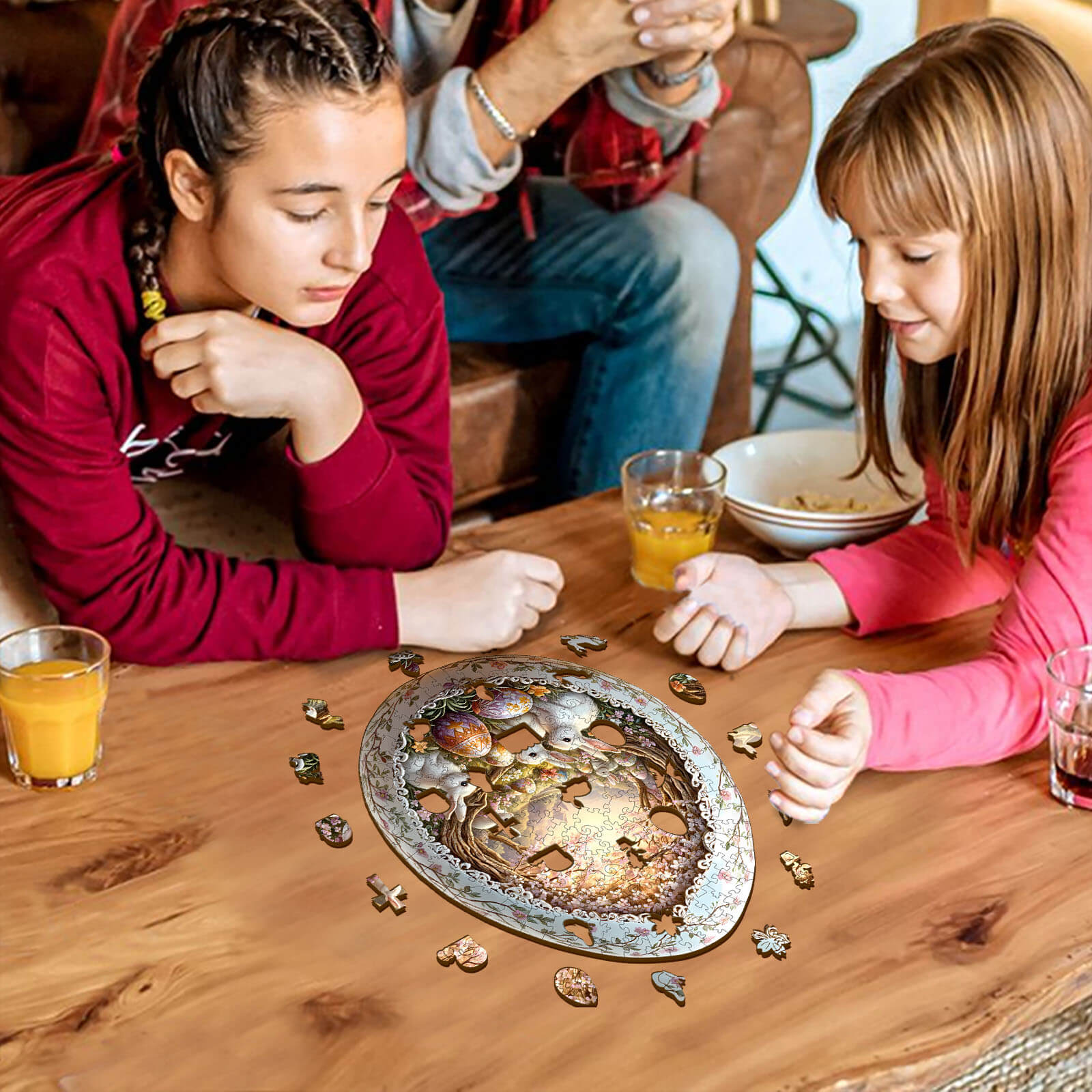 Two girls focused on assembling the Wonderland Easter-6 wooden jigsaw puzzle on a coffee table.