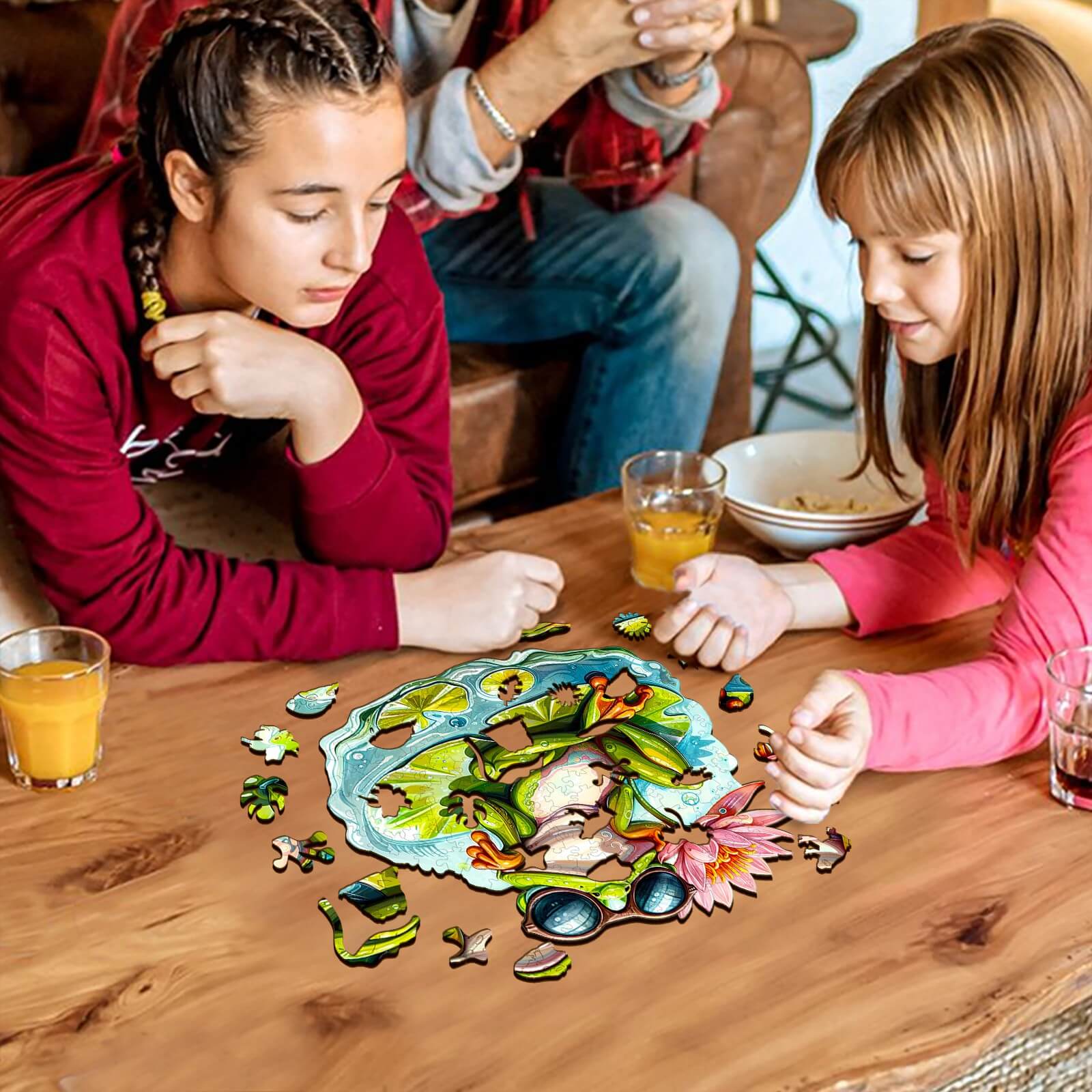 Two girls enjoy assembling the Leisurely Frog-1 Wooden Jigsaw Puzzle on a wooden table, enhancing focus and cognitive skills.