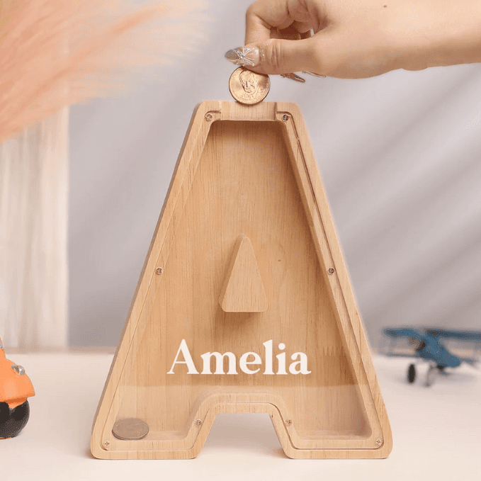 Personalized wooden letter piggy bank with the name Amelia, designed for teaching kids the value of saving money.