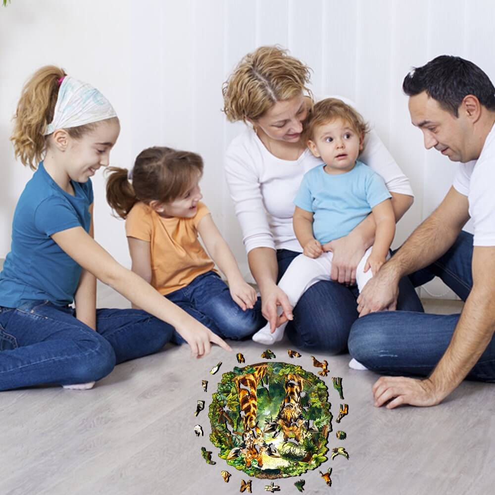 Family enjoying Giraffe-2 wooden jigsaw puzzle together on the floor, surrounded by children and vibrant jungle scene.