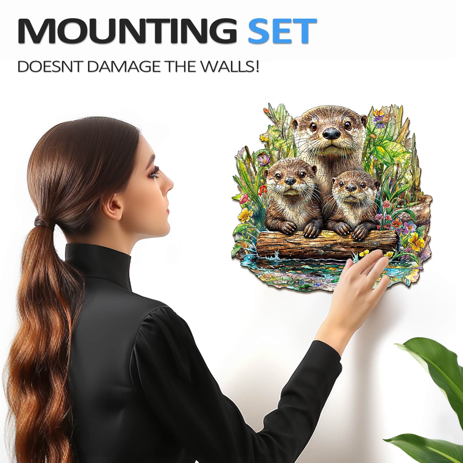 Woman attaching a decorative Otter jigsaw puzzle to the wall with a mount that doesn't damage surfaces.