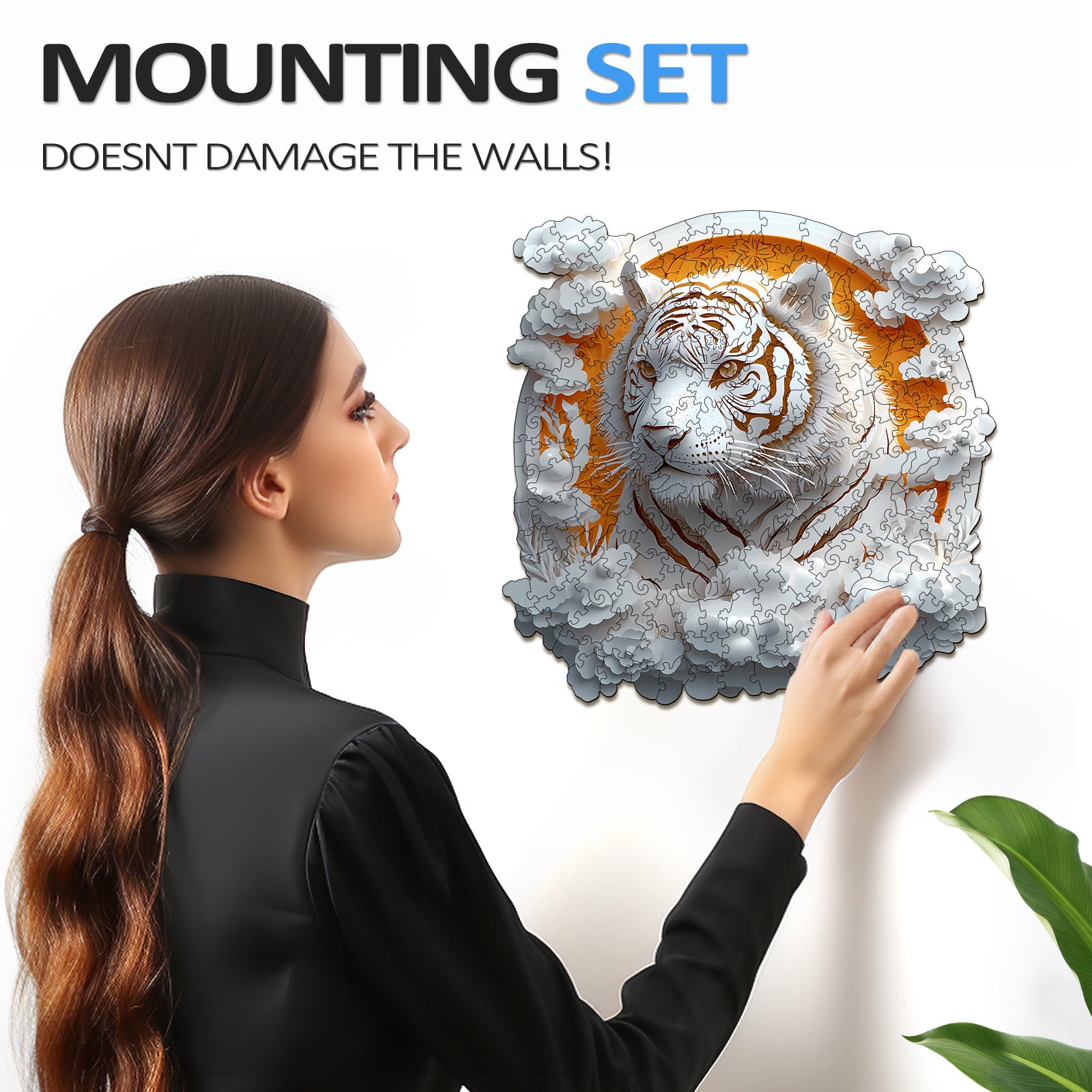 Woman using a mounting set to display a 3D Paper Tiger wooden jigsaw puzzle on the wall.