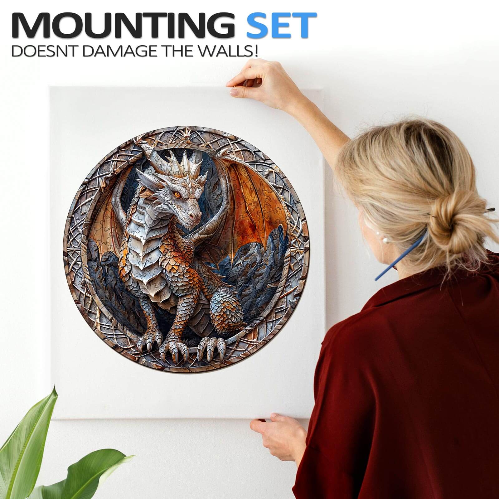 Person hanging a 3D Cave Dragon wall art with a mounting set that doesn't damage walls.