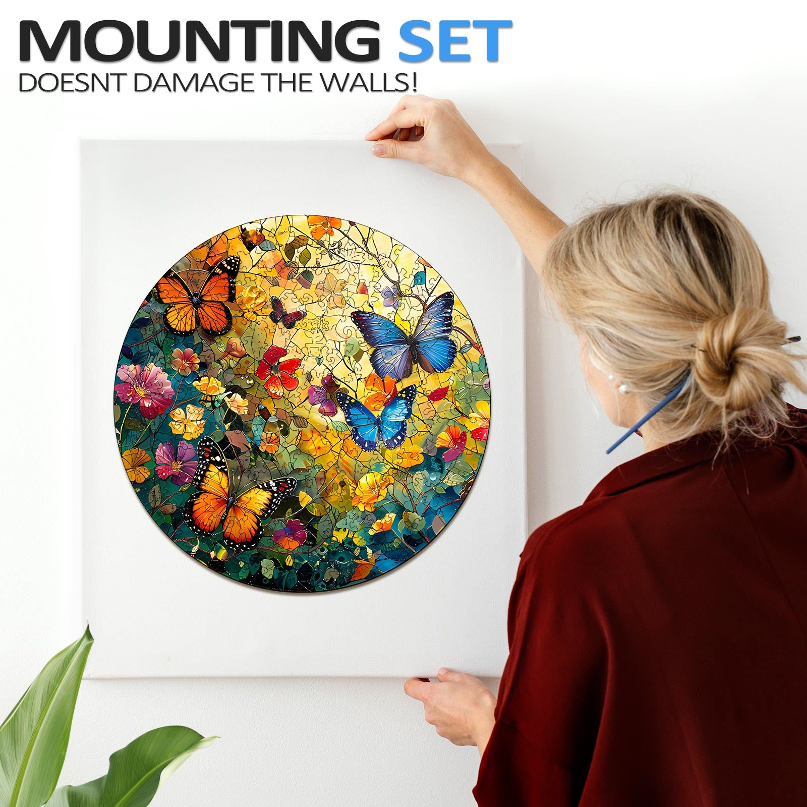 Woman mounting a colorful Butterflies and Flowers jigsaw puzzle with a non-damaging set on a wall.