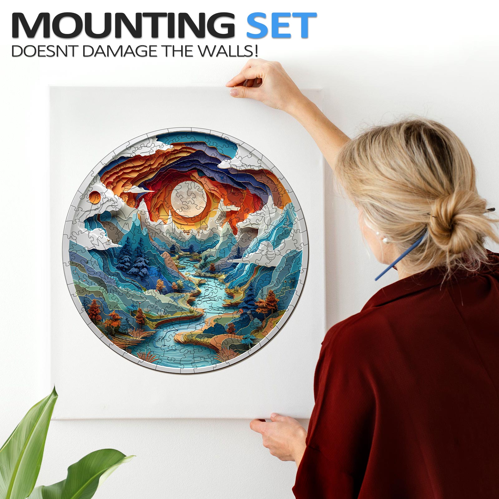Person hanging a 3D cave-themed jigsaw puzzle art using a mounting set that doesn't damage walls.