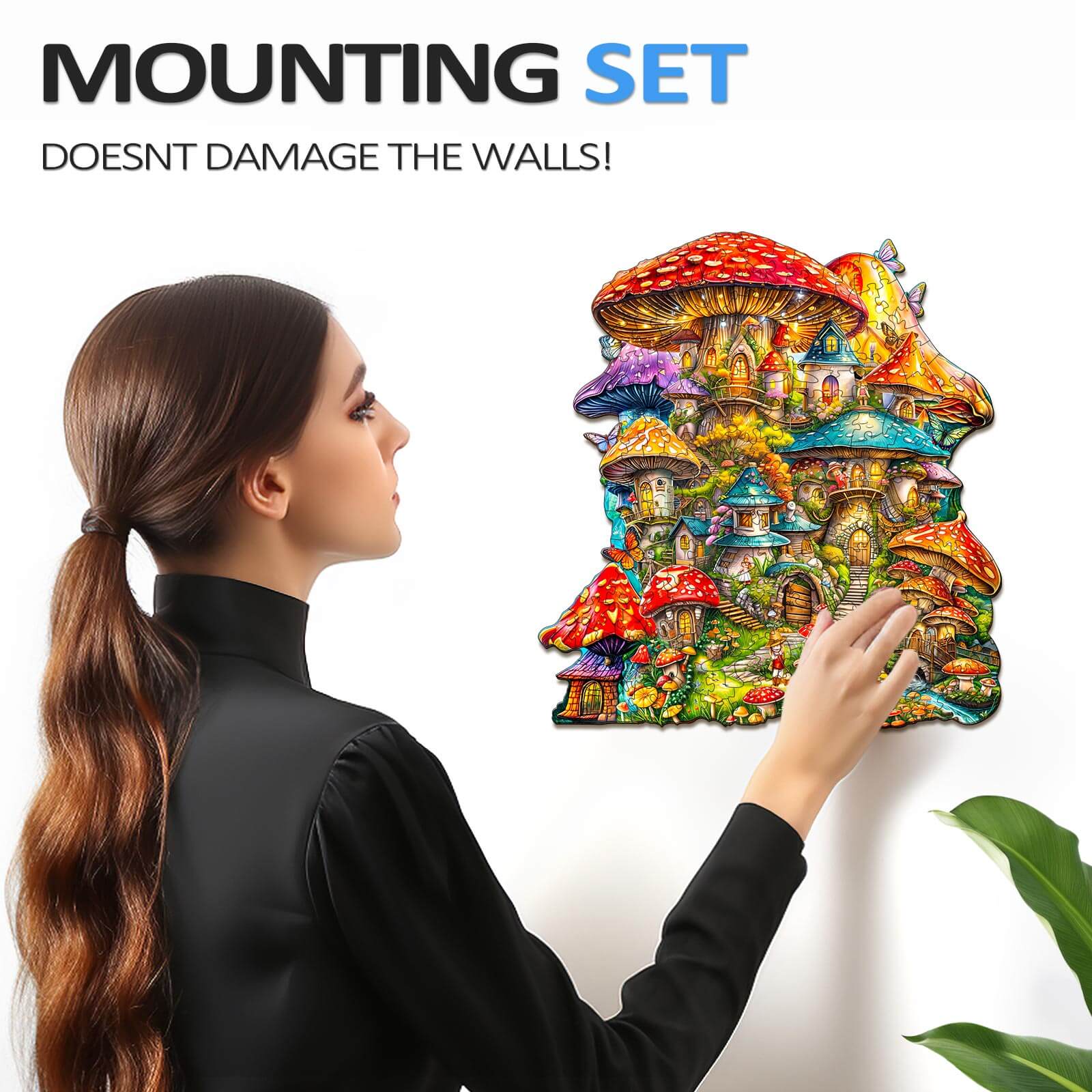 Woman mounting a colorful Mushroom House wooden jigsaw puzzle on the wall, showcasing its vibrant design and easy installation.