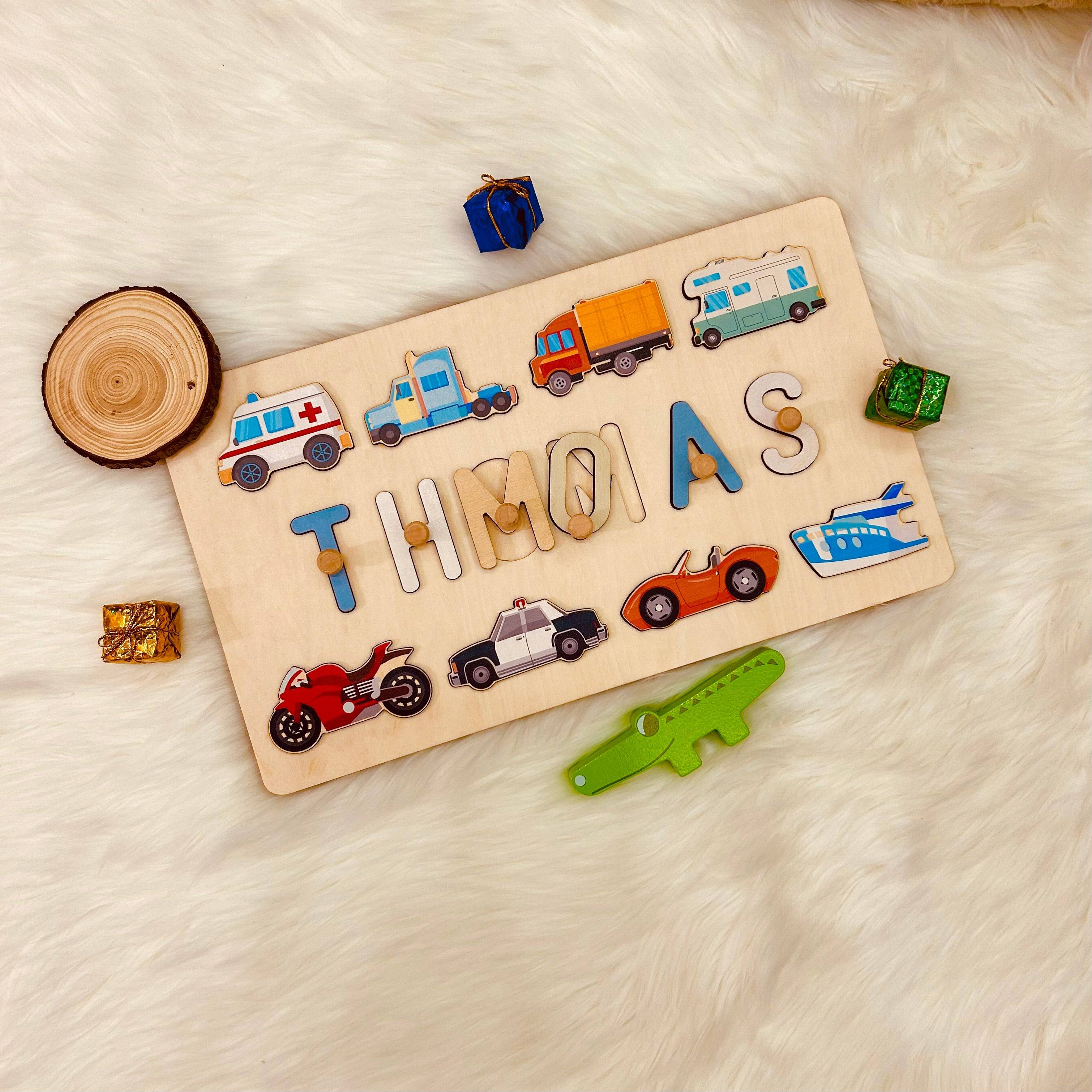 Personalized wooden baby name puzzle with traffic vehicles spelling THOMAS, made from eco-friendly materials.