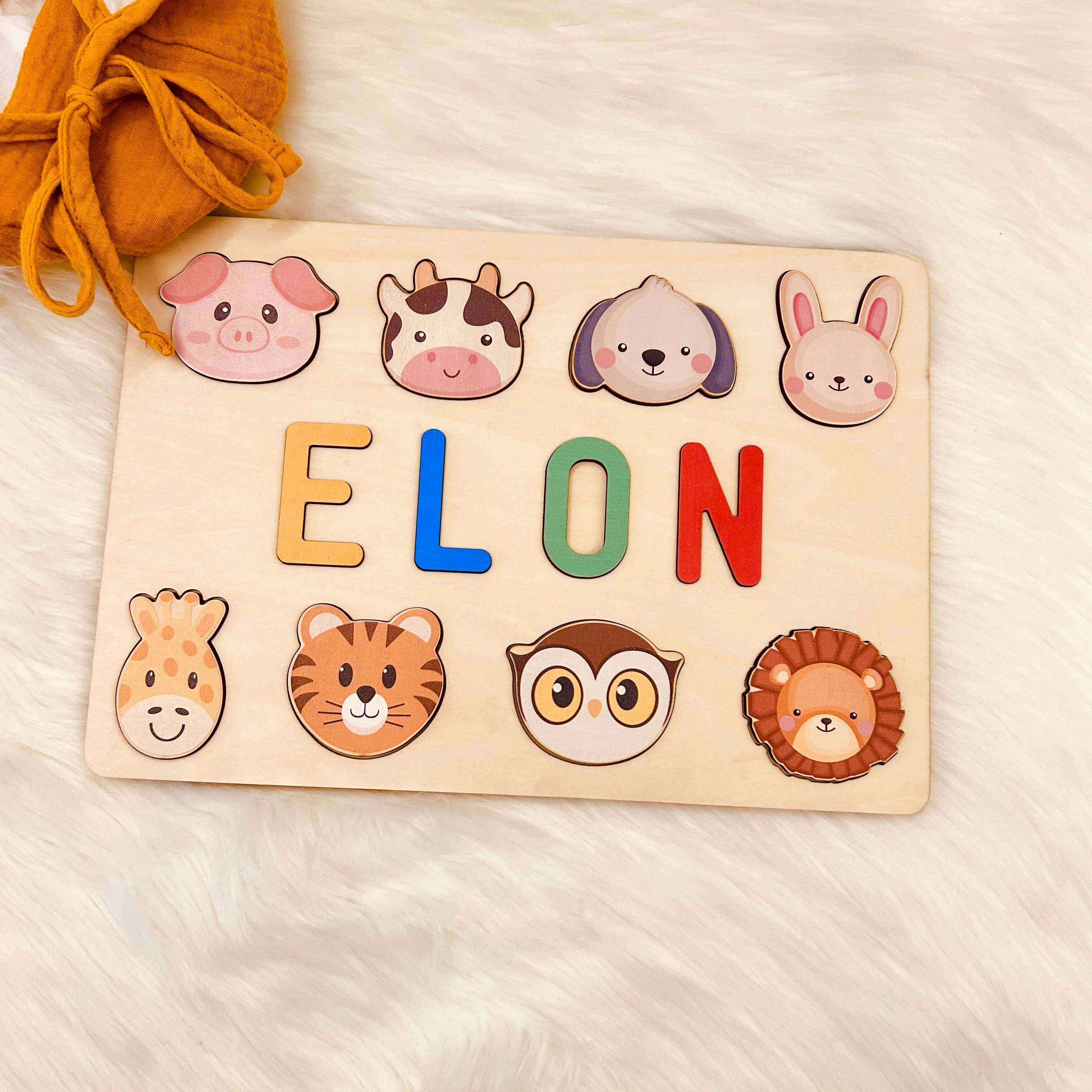 Personalized wooden baby name puzzle with animal graphics spelling 'ELON', ideal for kids' learning and play.