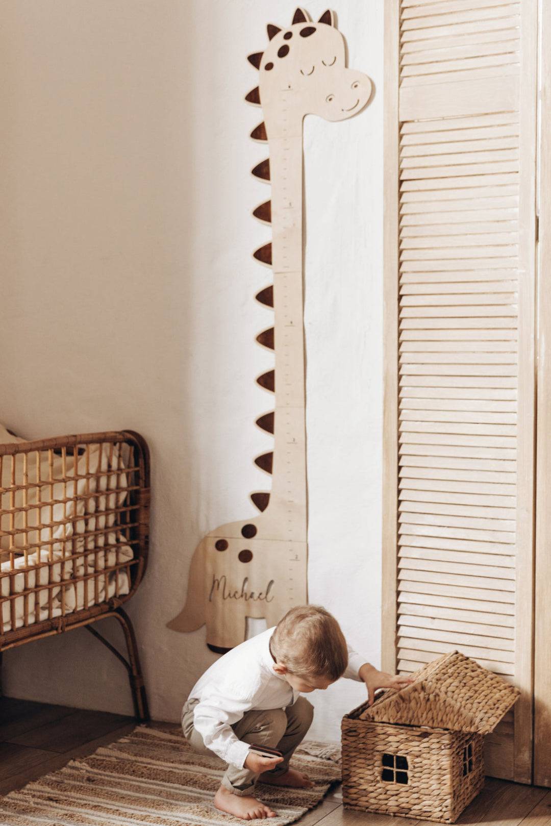 Personalized wooden dinosaur growth chart height ruler for kids in a stylish nursery with a child playing.