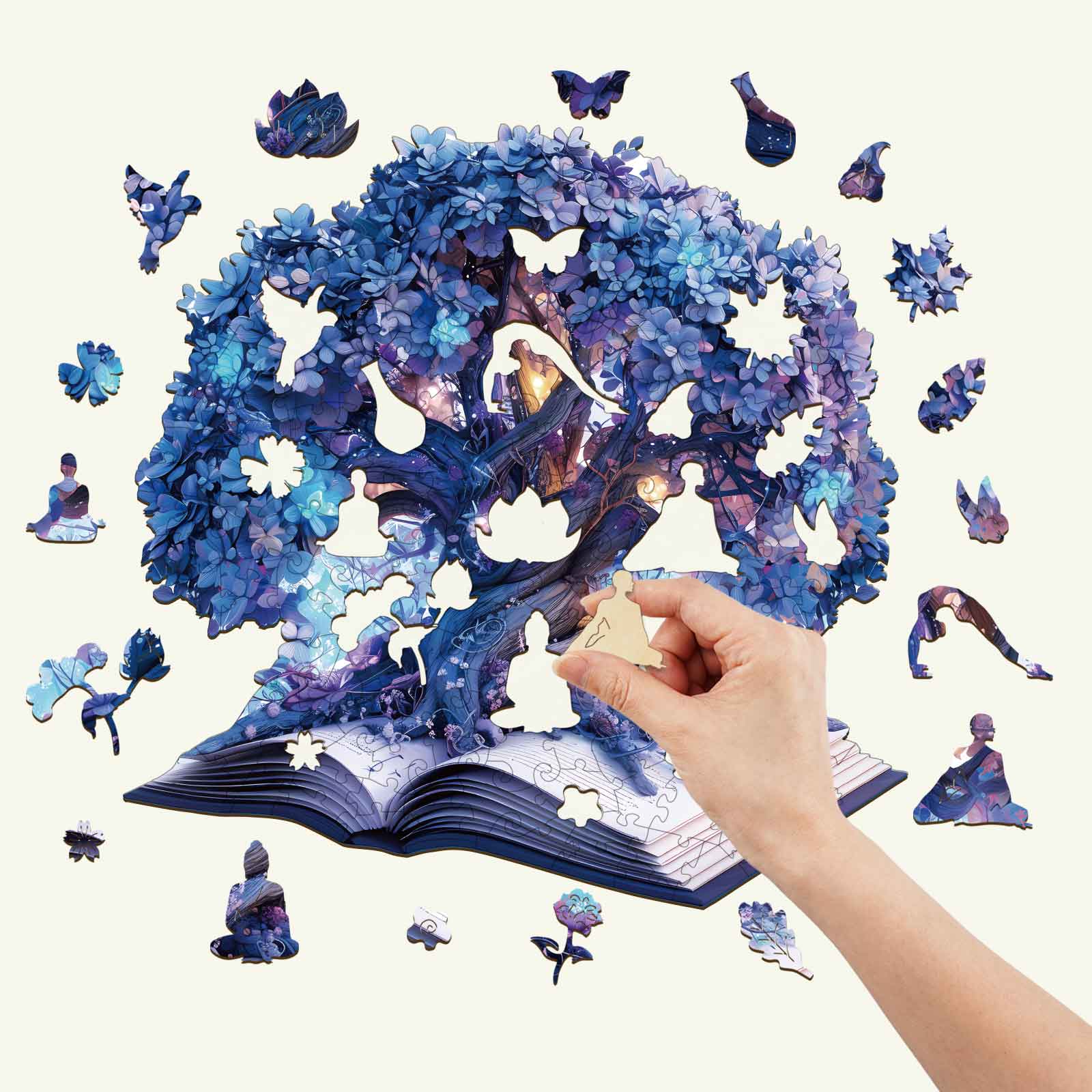 A hand completing the Magic Book Wooden Jigsaw Puzzle featuring a colorful tree and whimsical characters.