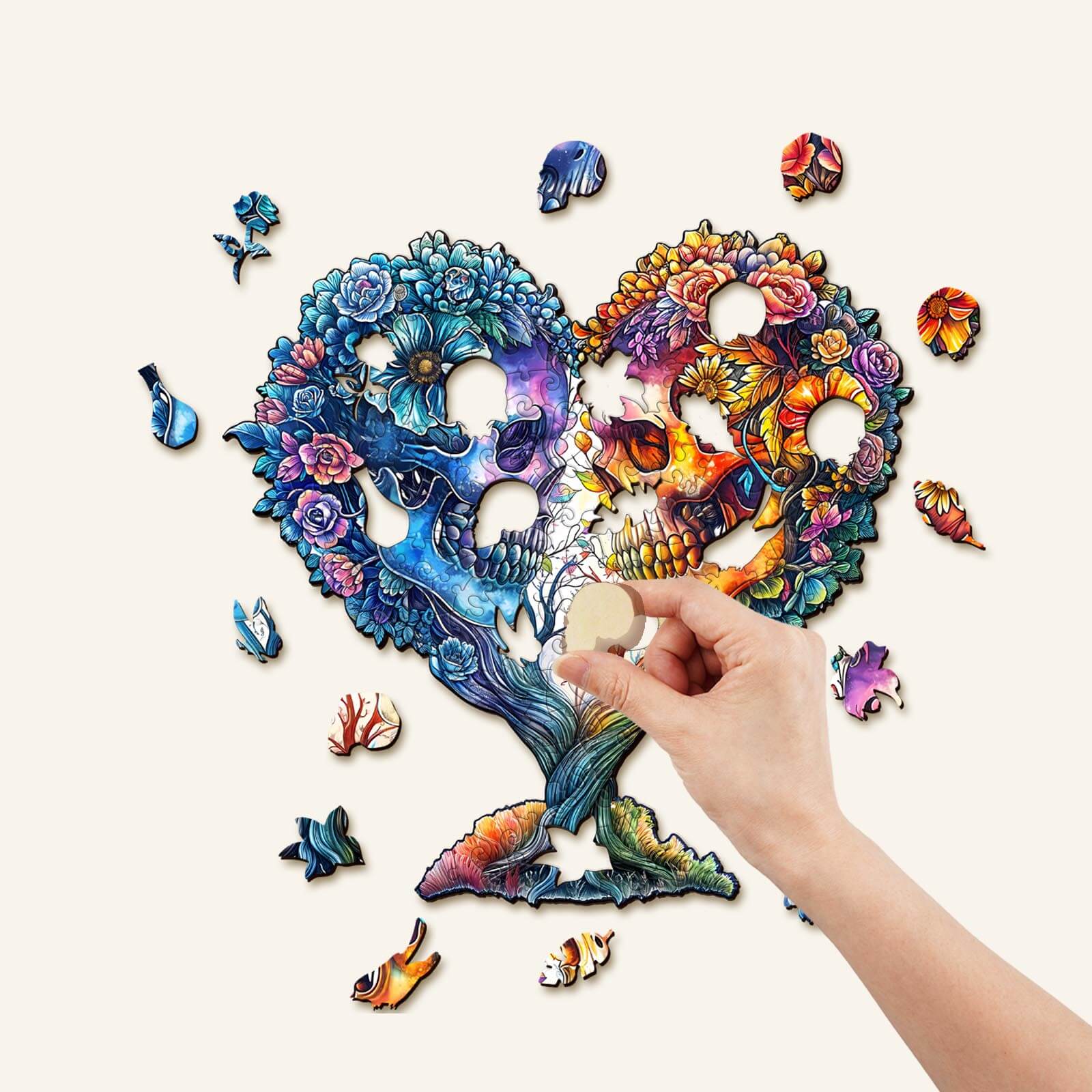 Hand inserting a piece into a colorful Skull and Love wooden jigsaw puzzle shaped like a heart.