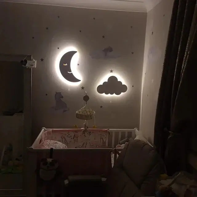 Moon and cloud wall light illuminating a nursery, providing a warm white glow for a cozy atmosphere.
