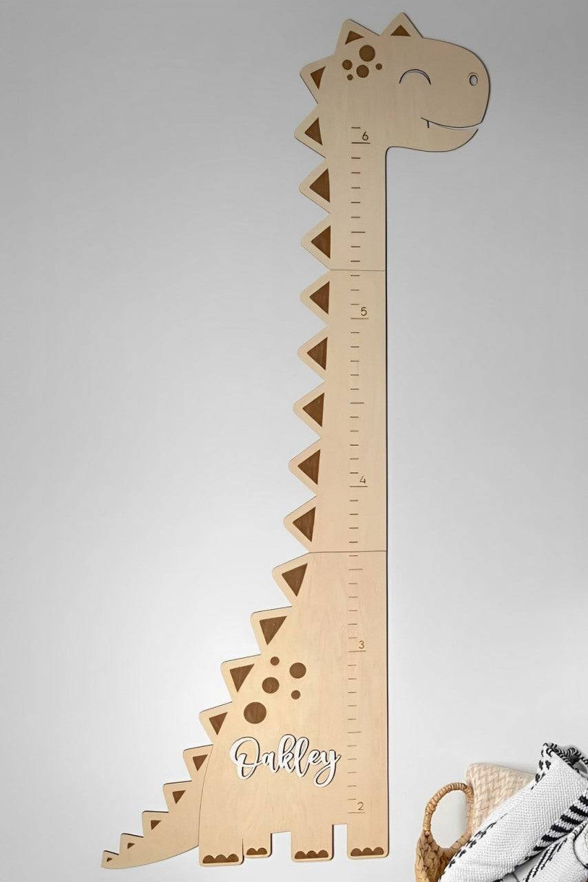 Personalized wooden dinosaur growth chart ruler with cute design and child's name for nursery decor.