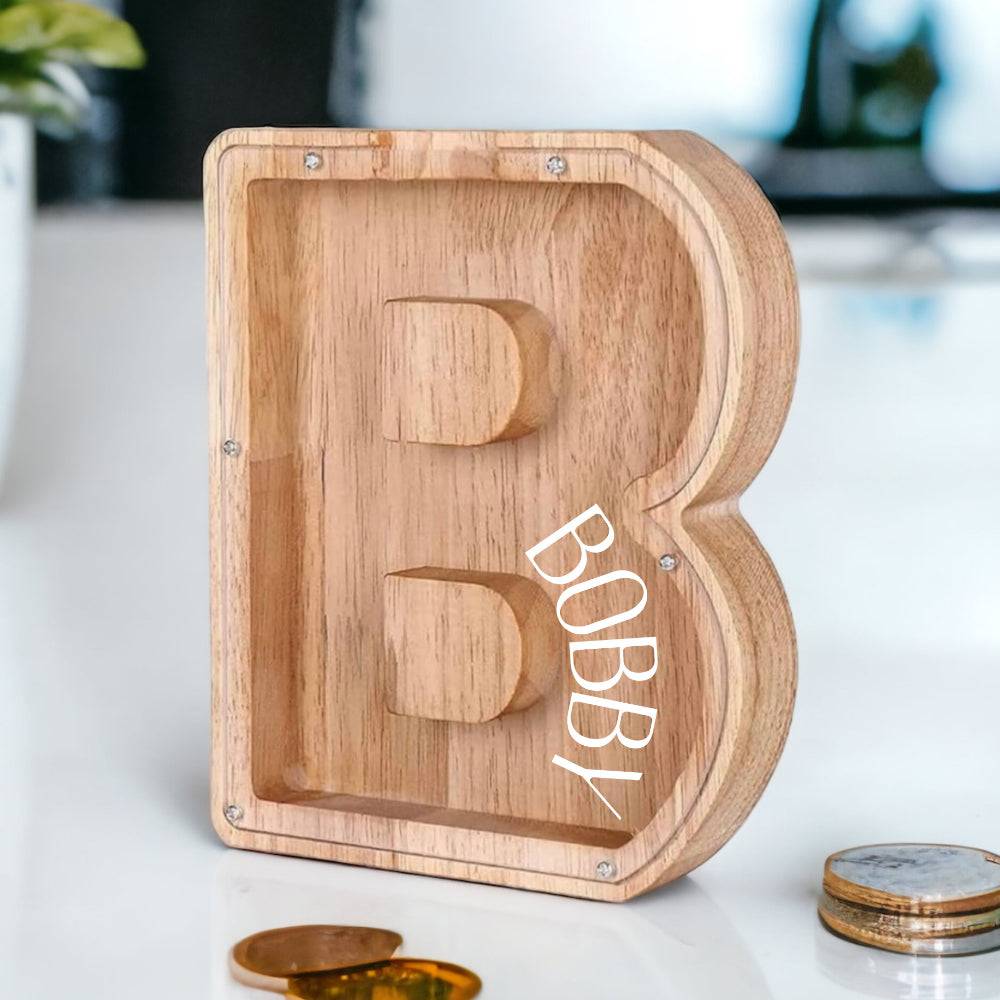 Personalized wooden piggy bank shaped as the letter B with the name Bobby, ideal for teaching kids about savings.