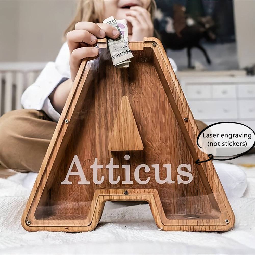 Personalized wooden letter piggy bank for kids, engraved with Atticus, teaching early financial awareness.