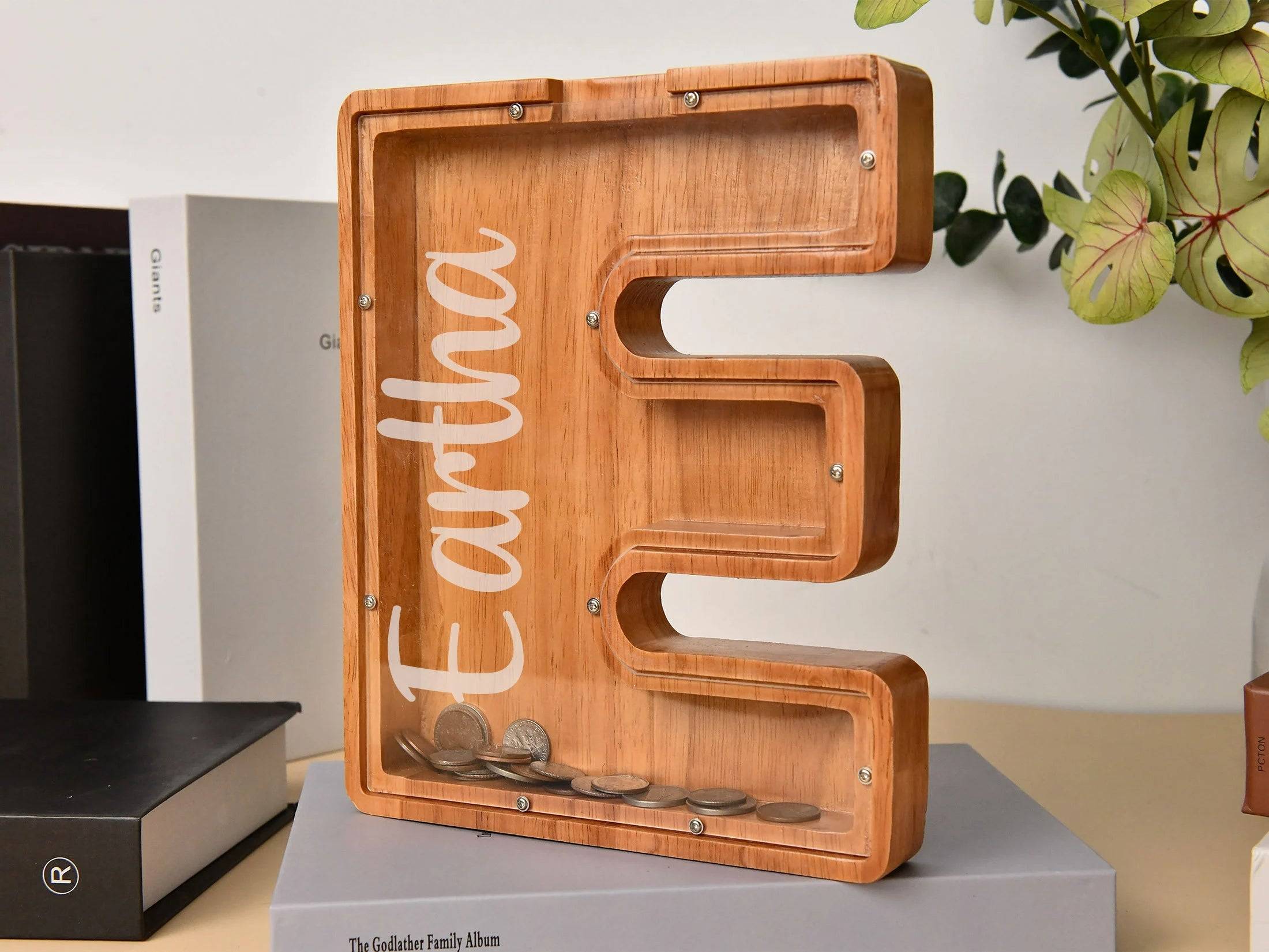 Custom wooden letter E piggy bank for kids, promoting financial awareness and savings in a stylish design.