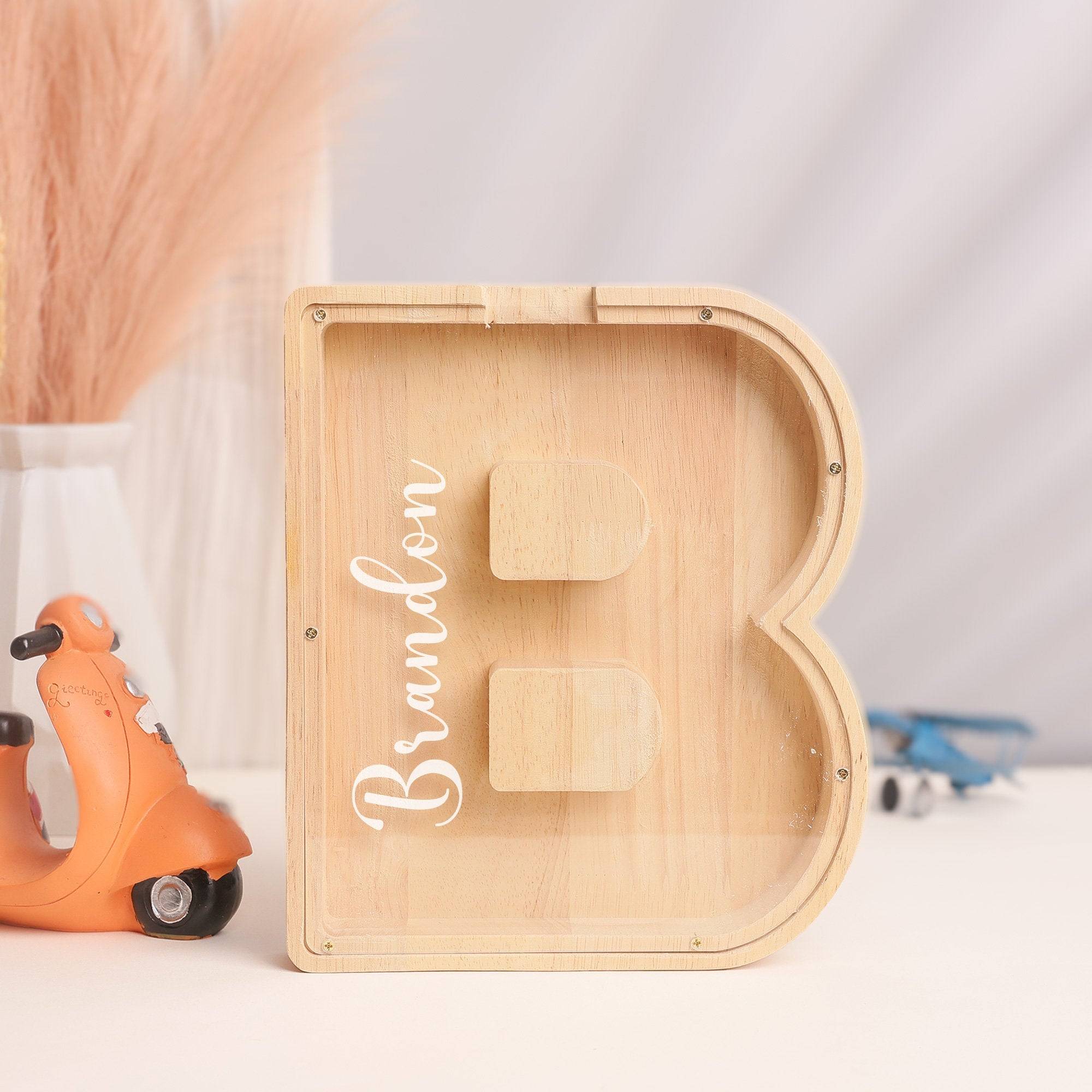 Personalized wooden letter 'B' piggy bank with name 'Brandon' for kids' savings education.