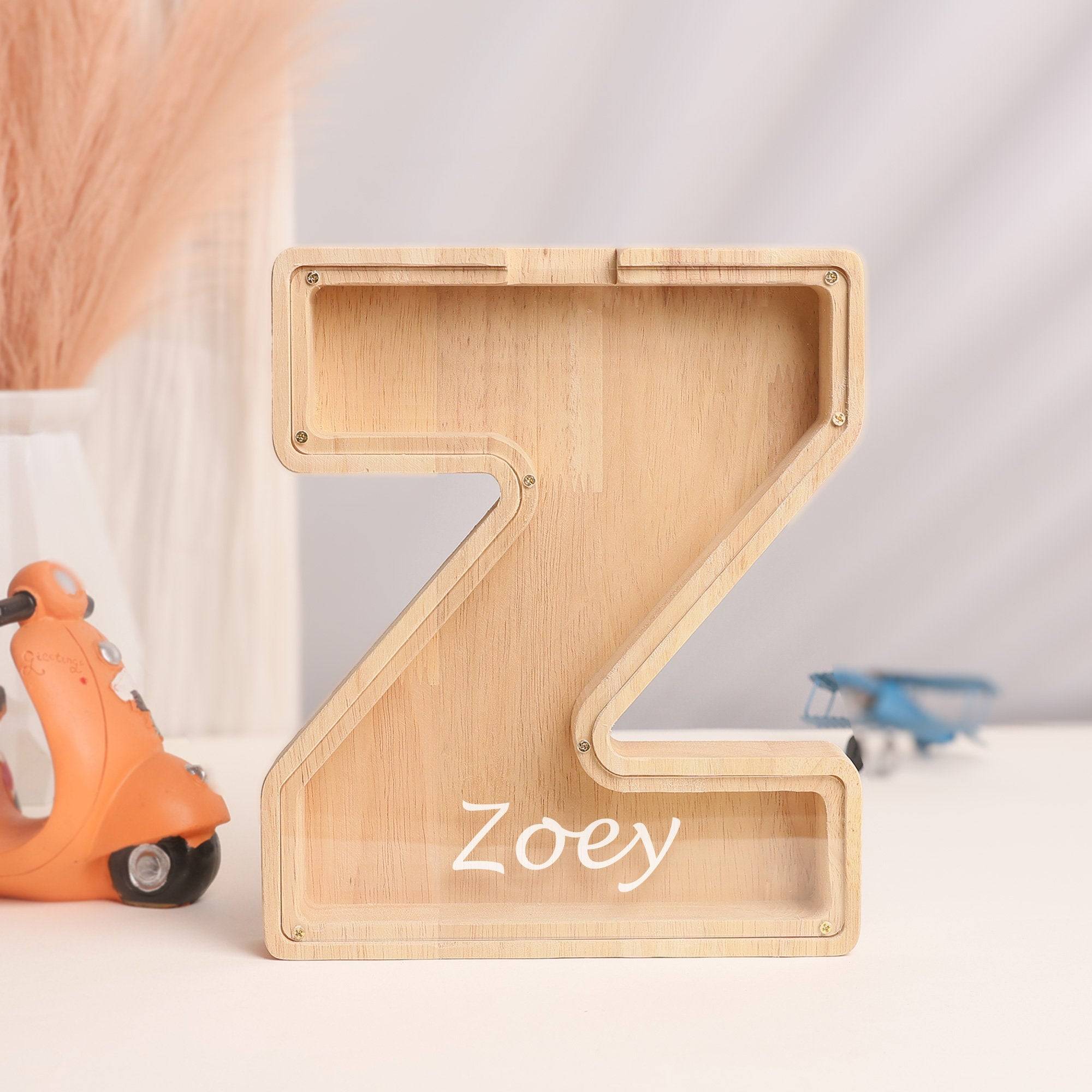 Personalized wooden letter 'Z' piggy bank for kids named Zoey, designed to teach children the value of savings.